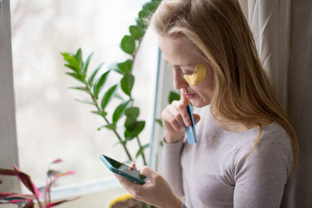 Shopping online without leaving their home. A European woman is shopping online, standing by the...