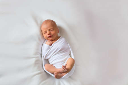 A light, gentle and clean photograph of a newborn baby. Newborn sleeping baby on a white background...