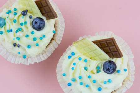 Top view of muffins with berries, chocolate and beads