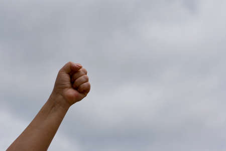 Clenched fist up against the sky. Struggle and leadership conceptの写真素材