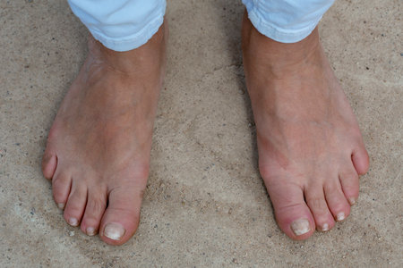 Bare feet of a woman aged on the concrete floor. Female feet without shoes