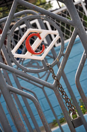 Cheboksary, Russia-August, 19, 2012. The emblem of the Spartak sports club on the stadium gates. On the emblem hangs a thick chain with a padlock. Vertical photo. The diagonal compositionのeditorial素材
