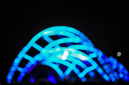 Blurred bokeh Light on a dark background. Defocused Image of an Illuminated outdoor stage area at Night. Unfocused stage lights and the crowd at the concertの写真素材