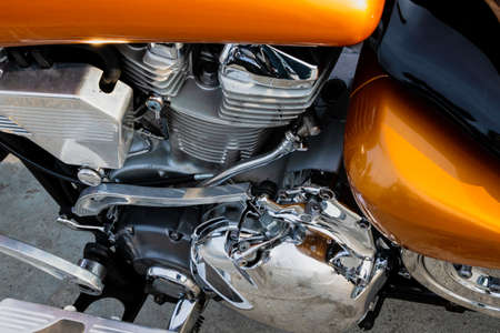 Modern powerful road bike with shiny chrome reflective engine surface with exhaust pipes in the street parking lot, close-up.の写真素材