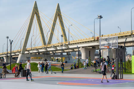 Kazan, Russia-September 26, 2020: In the city park on the embankment, young people play basketball, residents walk, children and teenagers race on scooters, skateboards and bicycles on the ride area.のeditorial素材