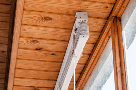 White plastic blinds on dusty windows with wooden frames.