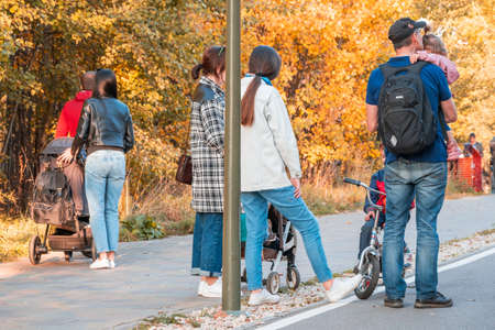 Kazan, Russia - October 03, 2020: Men and women with children in strollers and on their hands on a walk in the city park on a sunny autumn dayのeditorial素材