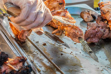 Fried shish kebab on skewers on the counter of a street restaurant. Food festival in the city park....