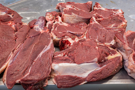 Fresh raw meat on the counter of a butcher shop in a farmer's market, butchered raw meat close-up.