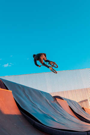 Bmx rider doing trick on ramp in skate park. Sports, extreme sports, freestyle, the concept of outdoor activity.の写真素材
