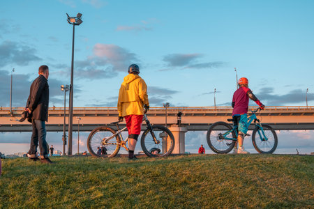 Young riders on BMX bicycles on the ramp of the skate park in the city public park for active...