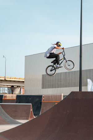 Kazan, Russia - September 26, 2020: A young rider on a BMX bike does tricks in the air. BMX freestyle in a skate park.のeditorial素材