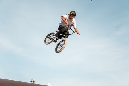 Kazan, Russia - September 26, 2020: A young rider on a BMX bike does tricks in the air. BMX freestyle in a skate park.のeditorial素材