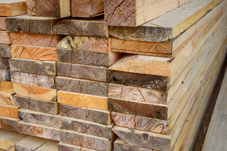 Piles of wooden planks at the sawmill for the manufacture of cladding. Warehouse of boards in the...