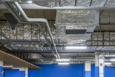 Underground parking of a commercial building. Air ducts of the air conditioning and ventilation...