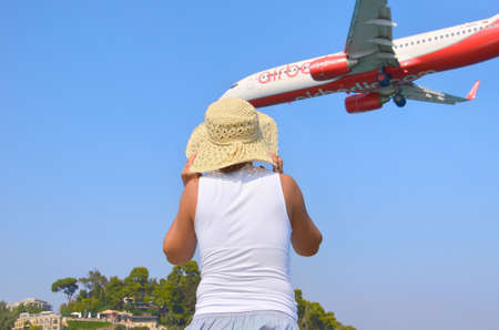 21.08.2012 Corfu island. The woman looks at the landing plane.のeditorial素材