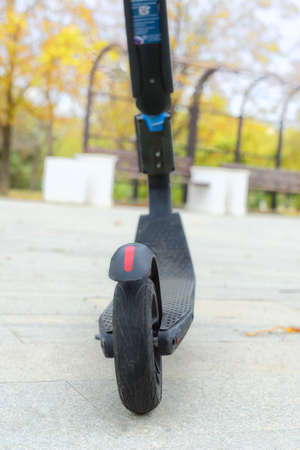 Rear wheel of an electric scooter in a parking lot. Autumn