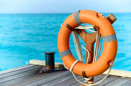 Lifebuoy on the background of the azure sea. Wooden sea pier in the sea.の写真素材