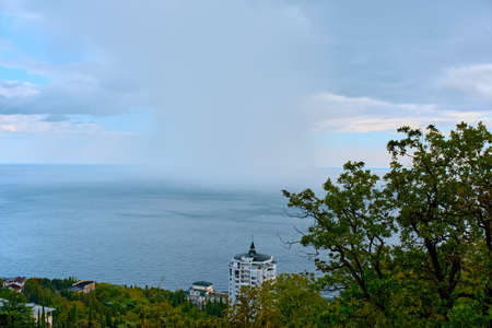 A rain front from the sea approaches the shore.