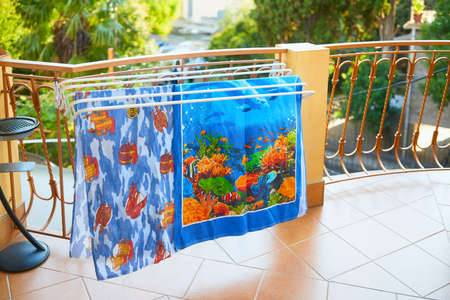 Colorful beach towels dry on the balcony. Rest on the sea.