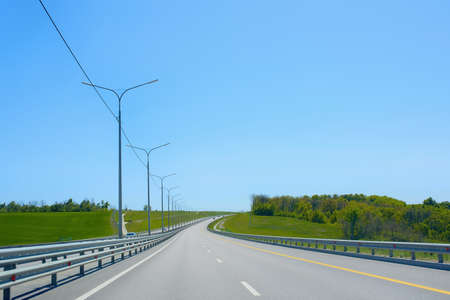 View of an asphalt road stretching into the distance with markings and bumpers along the edges. Highway M4 Don.の写真素材