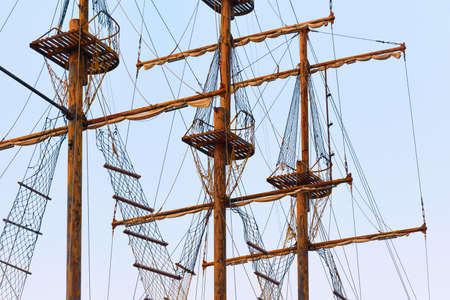 View of the masts with yardarms of a wooden ship. Tackle of a wooden sailboat - Mars baskets, ropes, shrouds, rope ladders.の写真素材