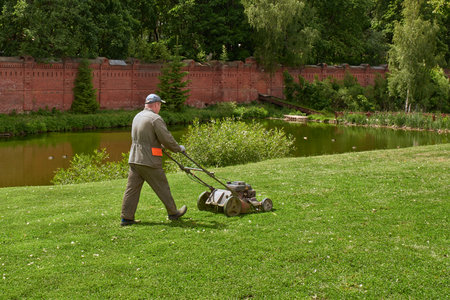 Sergiev Posad, Russia - June 10, 2023. Gardener mowing the lawn. landscape design.