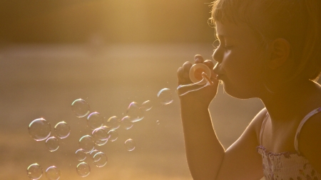Little girl having fun with soap bubbles      の写真素材