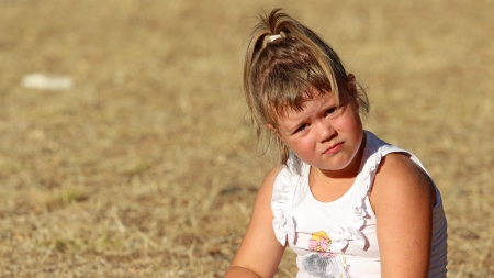 Tired little girl on the field     の写真素材