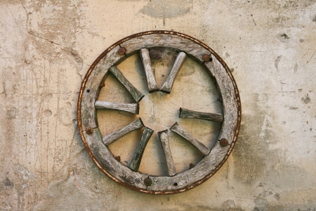 Old wagon wheel on the wallの写真素材