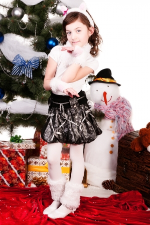 A girl stands near a Christmas tree, a beautiful girl in a cat costumeの写真素材