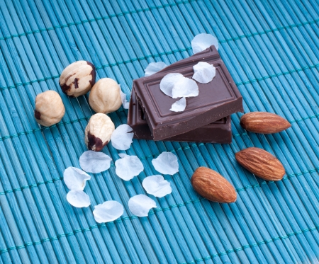 Chocolate with nuts on the background of beautiful flower petalsの写真素材