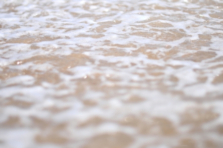 Sea wave over sand, sea wave rolls on a sandy beachの写真素材