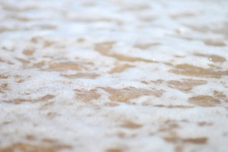 Sea wave over sand, sea â€‹â€‹wave rolls on a sandy beach