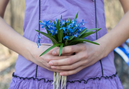 girl holding hands bouquet of blue snowdrops, hand holding blue snowdrops bouquetの写真素材
