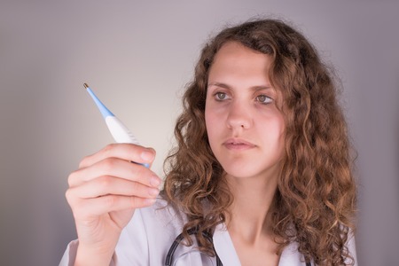 Medical female doctor with thermometer,doctor looking at thermometer