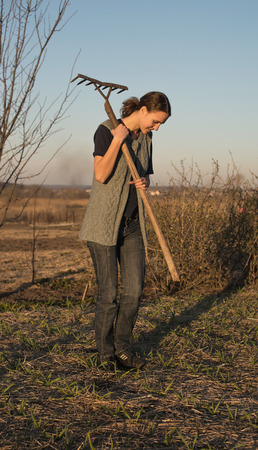 Female farmer  with spade in plowed field