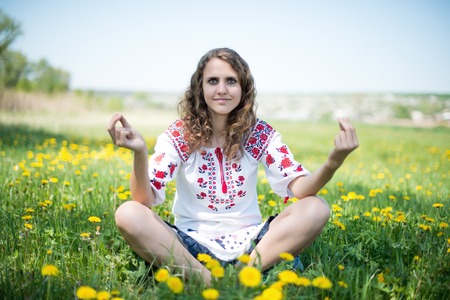 The young Ukrainian girl whit yellow flowers in the fieldの写真素材