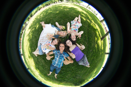 grupa students lie on the grass, photographed by fisheye
