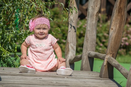 Pretty little girl sitting on a bridgeの写真素材