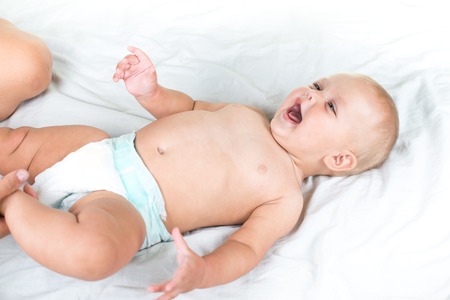 Baby massage. Mother massaging infant belly, kid laughing