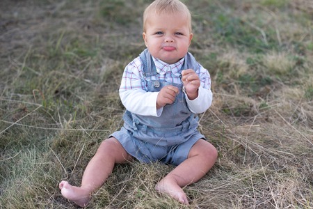 Little girl in the hay bale at the end of summer. Young girl in the field enjoying a summer afternoon.の写真素材
