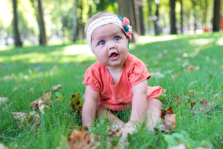 Portrait of a smiling little girl close up. Cute three years old child enjoying nature outdoors. Healthy carefree kid playing outside in summer park.の写真素材
