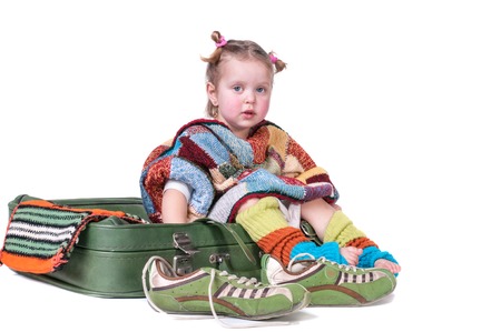 The little girl sitting on a suitcase.の写真素材