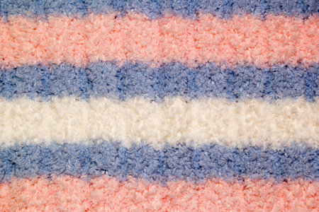 Knitted warm background of white, pink, blue colour. A soft, cosy knitted sweater of handworkの写真素材