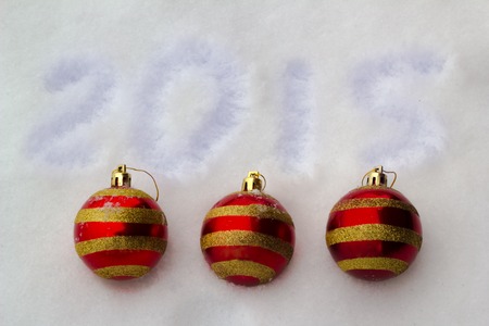 Red with a gold strip New Year's spheres and an inscription 2015 on snowの写真素材