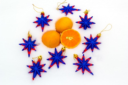 New Year's composition - three tangerines and decorative stars on snowの写真素材