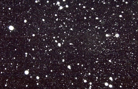 White flakes of snow on a black background. It is possible to use as a backgroundの写真素材