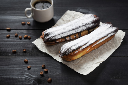 A horizontal photo of chocolate eclairs with sugar powderの写真素材