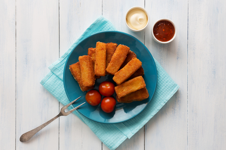 Horizontal photo of fried cheese sticks with sauces and tomatoesの写真素材